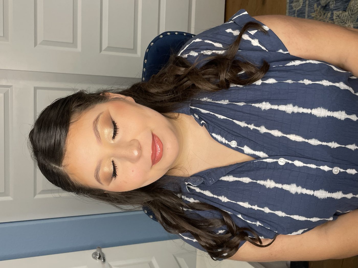 Soft glam makeup with gold shimmer eyeshadow and a glossy coral lip